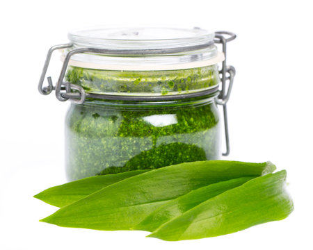 Wild garlic leaves in front of a glass with wild garlic pestoの写真素材