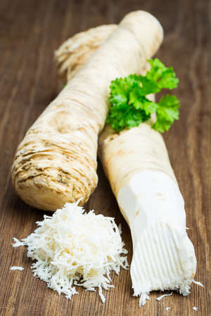 Two horseradish roots on a wooden boardの写真素材
