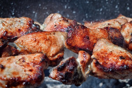 Pieces of grilled pork with red crust on brazier over the coals cooking tastyの写真素材