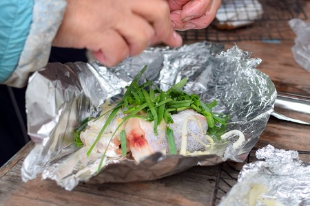 Cooking of fresh fish with green onions in foil tastyの写真素材