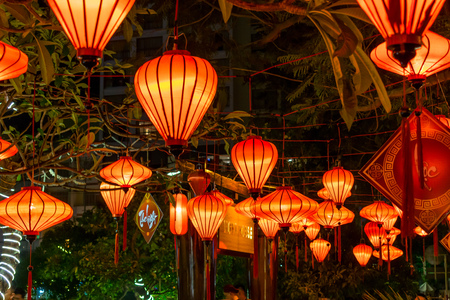 Red chinese lanterns on trees with green branch in night cultureの写真素材