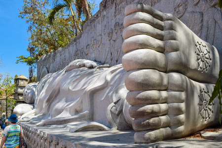 Tourists are beside lying buddha with symbol of solstice in pagoda in nha trangの写真素材