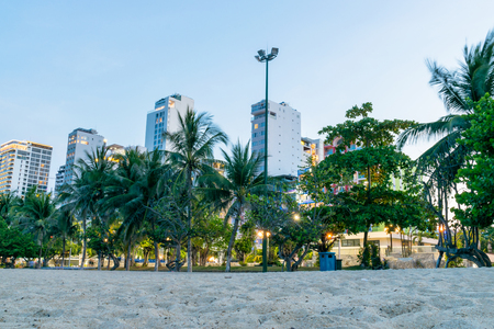 Tropical trees and buildings of hotels on beach with lights in dusk in Nha Trangの写真素材