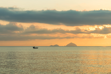 Lonely fishing boat of in sea at dawn with the colorful skyの写真素材