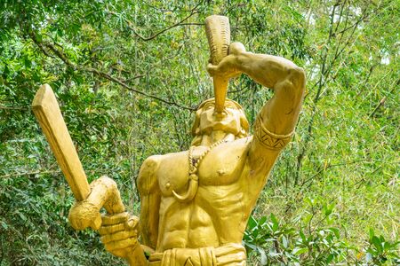 Golden statue of warrior with horn and amulet in shape of a fangの写真素材