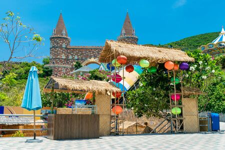 Straw gate with Chinese colorful lanterns with a fairy castle on mountain in backgroundの写真素材