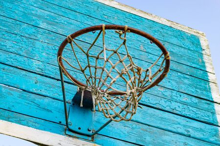 Rusty metal ring with basketball net and blue wooden shieldの写真素材