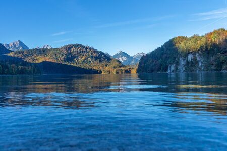 Reflection of mountains and shores on the surface of a lake in the Alps in the morning at autumnの写真素材