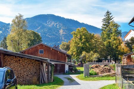 Village house with a bunch of firewood against mountains in the Alps in autumnの写真素材
