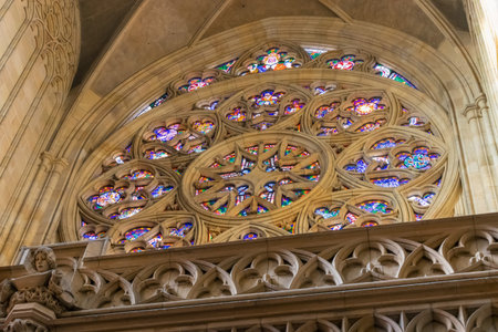 Sunlights through colorful stained glass in a patterned window in St. Vitus Cathedral in Prague