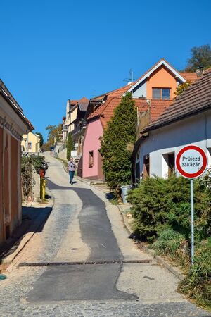 PRAGUE, CZECH REPUBLIC - OKTOBER 11, 2018: A lonely man walks along narrow street between houses in Europe with road signのeditorial素材