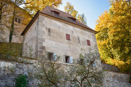 Ancient building with open windows and a brown roof in autumn in Europe in Krumlov