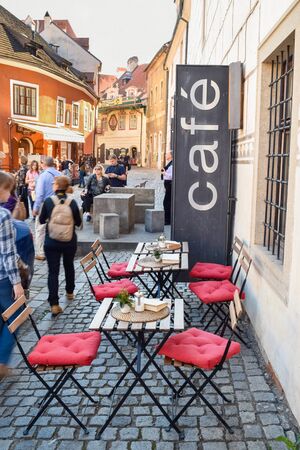 PRAGUE, CZECH REPUBLIC - OKTOBER 11, 2018: Tourists near red chairs and tables in street cafe in Czech Republicのeditorial素材