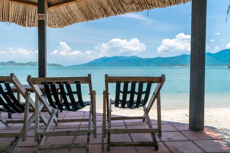 Wooden chairs on terrace on the beach by the sea in the tropics vacation and relaxationの写真素材