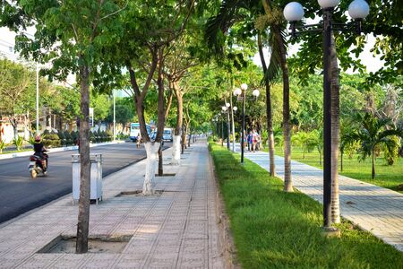 NHA TRANG, VIETNAM - APRIL 18, 2019: Tropical trees and footpath along road in Vietnam in the morningのeditorial素材