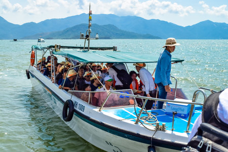 NHA TRANG, VIETNAM - APRIL 18, 2019: A group of tourists in full boat at sea and captain in hat on sea