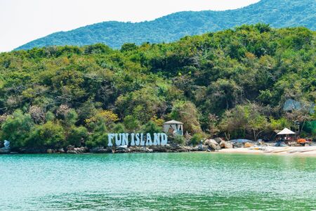 The inscription on the hill and the tent on the sandy beach in tropicsの写真素材