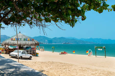 NHA TRANG, VIETNAM - APRIL 21, 2019: An old car in the sand and a cafe on the beach in tropicsのeditorial素材