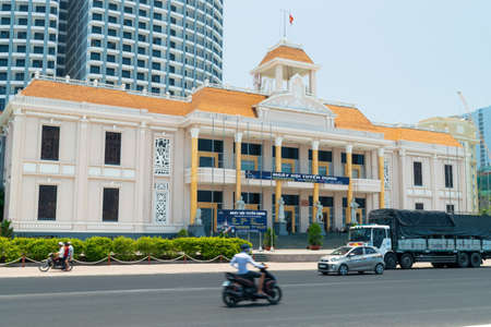 NHA TRANG, VIETNAM - APRIL 21, 2019: Solemn building with flag and hotel in background along roadのeditorial素材