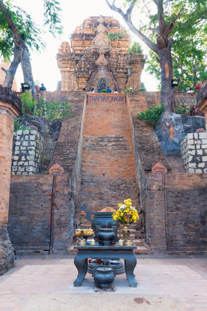 NHA TRANG, VIETNAM - APRIL 21, 2019: Altar with offerings and flowers and staircase to the red brick...