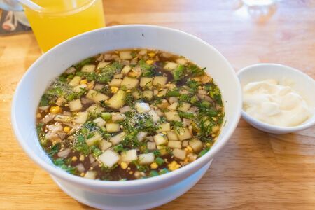 Potato soup with green onions and sour cream on tableの写真素材