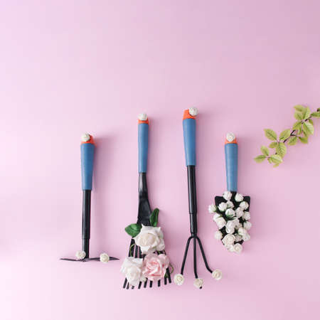 Aesthetic set of gardening tools decorated with flowers on soft pink background.の写真素材