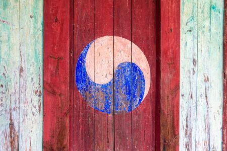 Eum and Yang Symbol, korean style of Yin and Yang. Colorful retro painting with red background on a wooden door.の写真素材