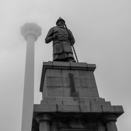 Detail view of Busan Tower and Statue of Admiral Yi Sun-sin in front on a foggy day. Jung-gu, Busan, South Korea. Asia.の写真素材