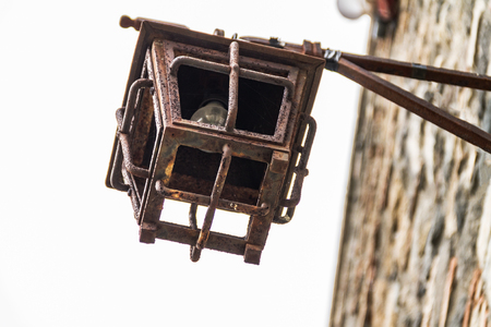 An antique iron street lamp hanging on the castle wall, a rusty metal street lampの写真素材