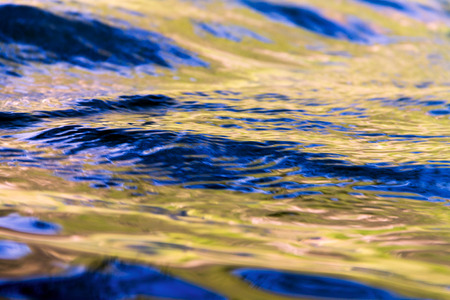 The color of the sky and the trees shimmers beautifully on the waves, the beautiful glow of the waterの写真素材