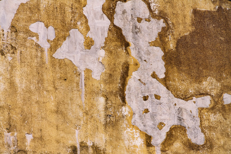 The old wall is peeling, the wall in the holes is destroyed by the rainの写真素材