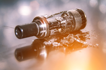 Broken vaping on the table with small pieces of glass. broken glass tankの写真素材