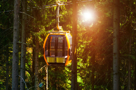the funicular passes through the forest, the exit from the mountain through the forest, the rays of the sun shine through the treesの写真素材