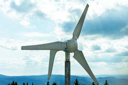 The wind turbine produces electricity, alternative energy. Turbine blades against the background of mountains and skyの写真素材