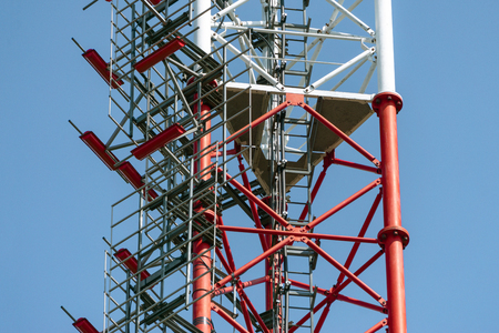 Mobile phone communication antenna tower with silhouette in sunset sky backgroundの写真素材