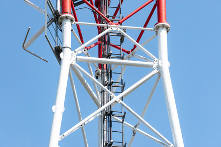 Mobile phone communication antenna tower with silhouette in sunset sky backgroundの写真素材