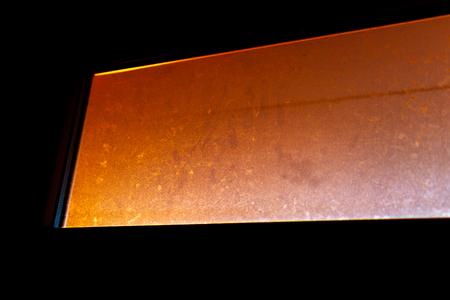 Dirty window illuminated by sunlight, sunset, view through the windowの写真素材