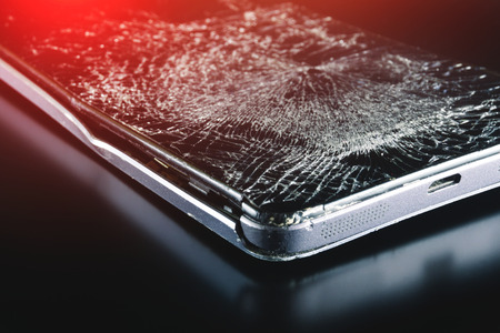 Broken phone on black background, phone repair advertisementの写真素材