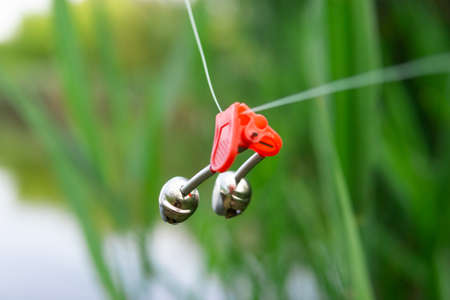 Fishing bell hanging on a fishing lineの写真素材
