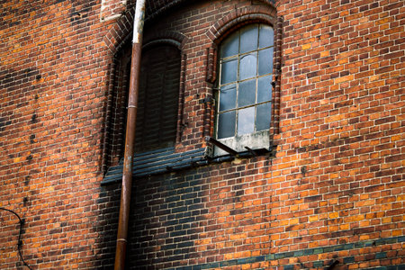 Chimney sweep cleaning a chimney standing balanced on the apex of a house roof lowering equipment...