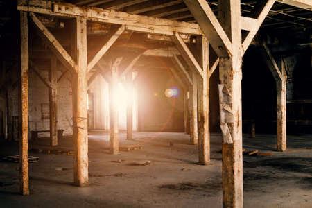 Old wooden columns. Old abandoned warehouse, illuminated by light from the window.の写真素材