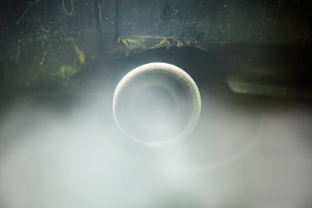 Exhaust gases from the muffler of the car. Close-up. White smoke. The concept of harm to the environment from internal combustion enginesの写真素材