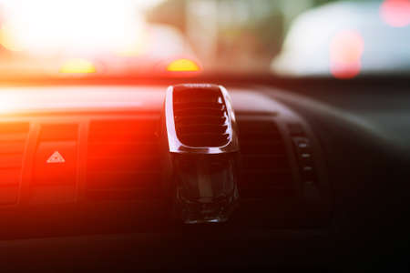 A small glass bottle with perfume for a car is fixed on the diffusers, an air diffuser in the car.の写真素材