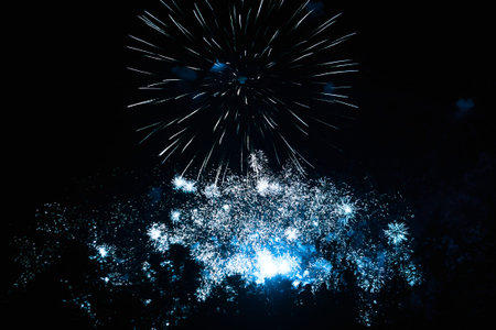 Bright blue fireworks in the night sky. New Year celebration