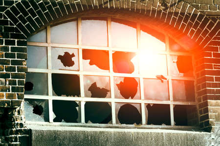 broken glass reflecting the blue sky and red sun. Old house architecture.の写真素材