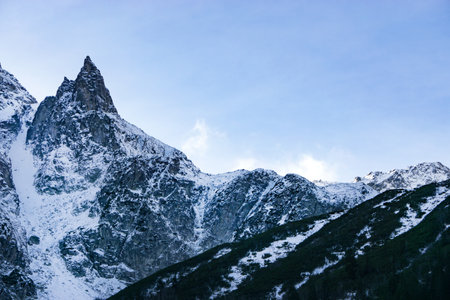 Snow-capped mountains in the Alps. Clouds flying near the tops of the mountainsの写真素材