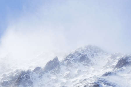 Snow-capped mountains in the Alps. Clouds flying near the tops of the mountainsの写真素材