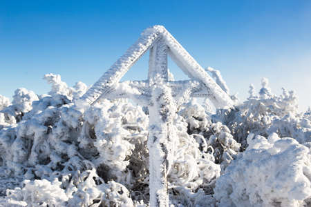 Cross on the top of the mountain in winterの写真素材