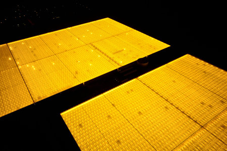 Greenhouses at night brightly illuminate the sky, from a height of
