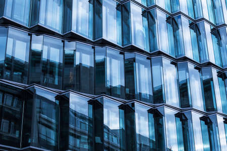 Modern glass facade of an office building, reflection of the sky in the Windows.の写真素材